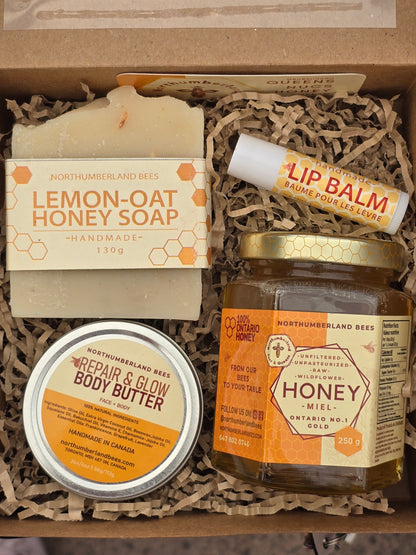 Collection of Northumberland Bees products including soap, lip balm, body butter, and honey in a box.